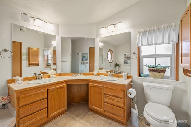 bathroom featuring a textured ceiling, toilet, and vanity