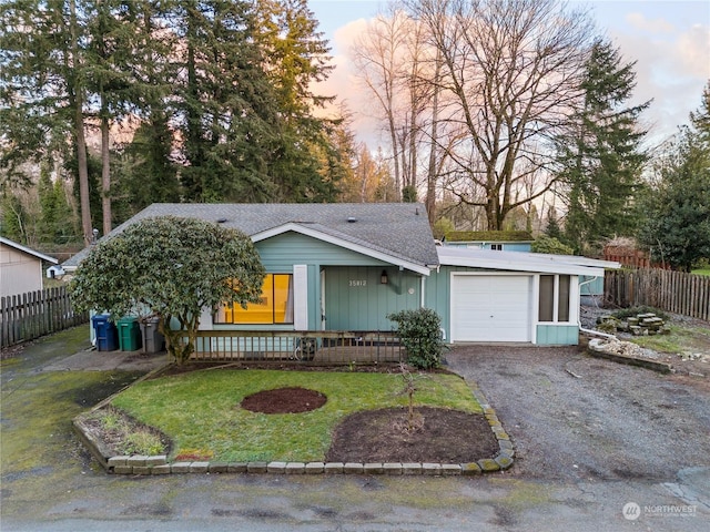 ranch-style house with a garage and a yard