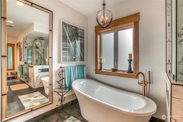 bathroom featuring a marble finish shower, a soaking tub, and an inviting chandelier