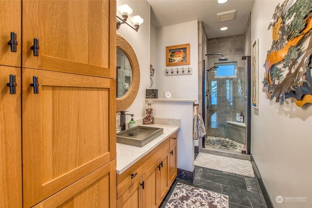 bathroom featuring vanity, visible vents, a stall shower, and baseboards