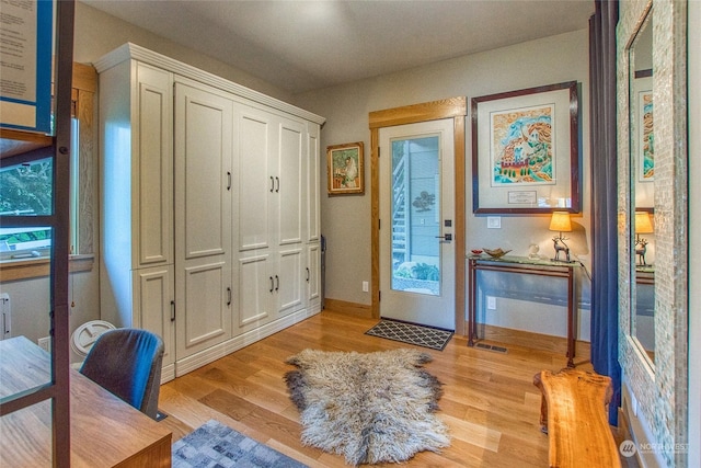 foyer entrance with light wood finished floors and baseboards