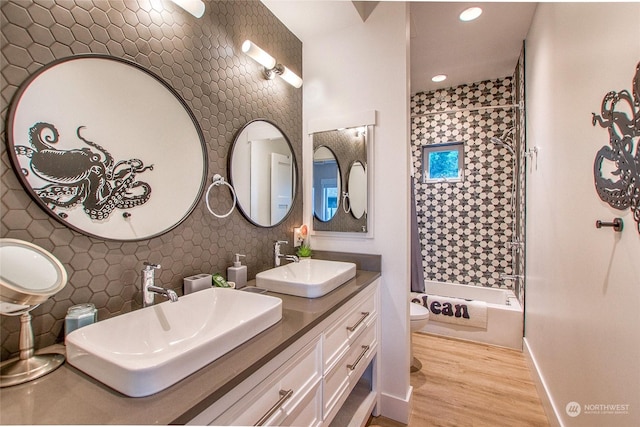 bathroom featuring a sink, toilet, tub / shower combination, and wood finished floors