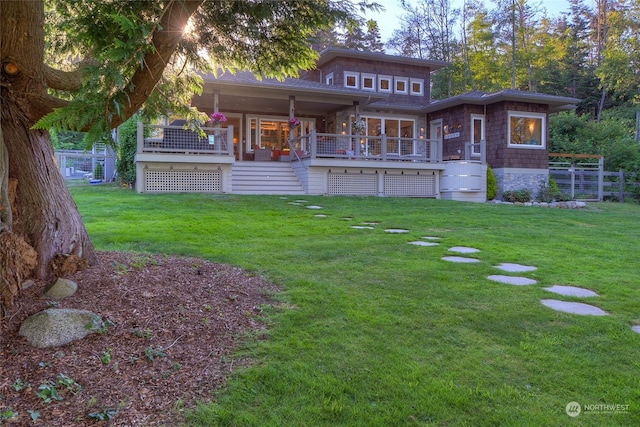 rear view of house with stairway and a lawn