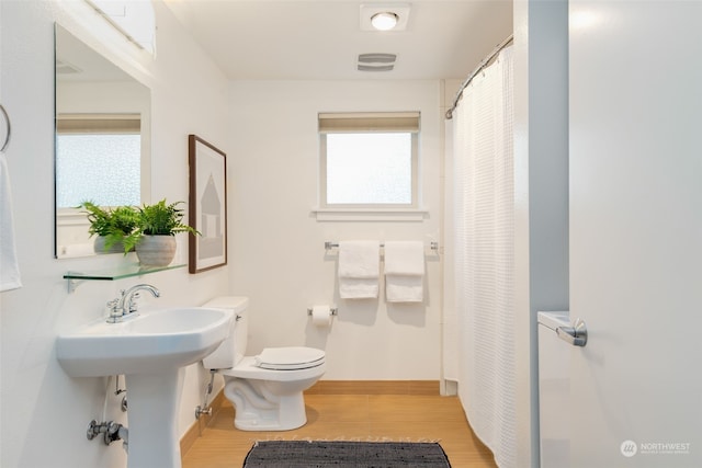 bathroom featuring sink, wood-type flooring, and toilet