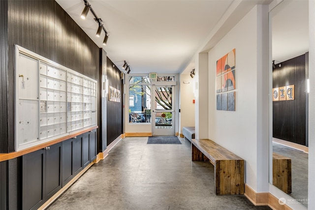 hall featuring concrete floors and mail boxes