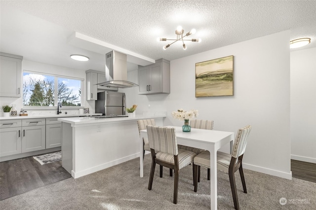 dining area with sink, a textured ceiling, and a chandelier