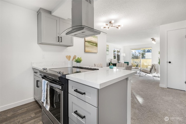 kitchen with a textured ceiling, gray cabinetry, island range hood, kitchen peninsula, and stainless steel range with electric cooktop