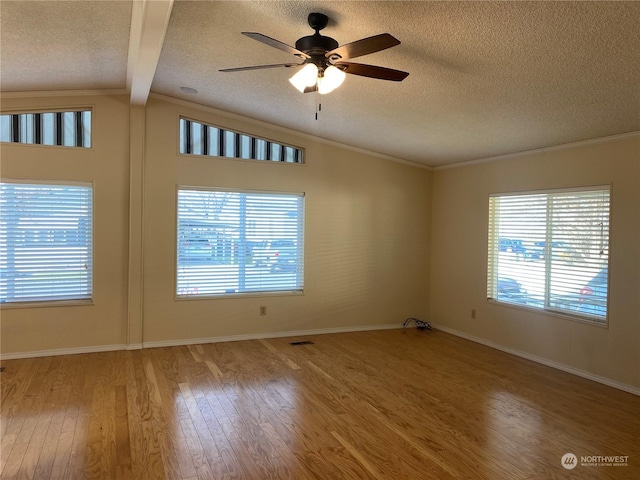 empty room featuring hardwood / wood-style flooring, ceiling fan, a textured ceiling, and vaulted ceiling with beams