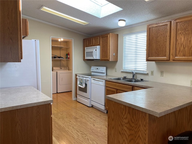 kitchen with sink, white appliances, light hardwood / wood-style flooring, kitchen peninsula, and independent washer and dryer