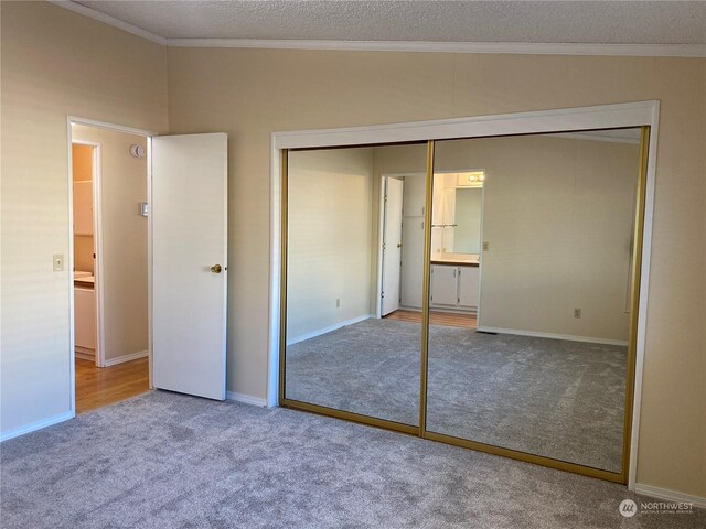 unfurnished bedroom featuring ornamental molding, carpet floors, and a closet