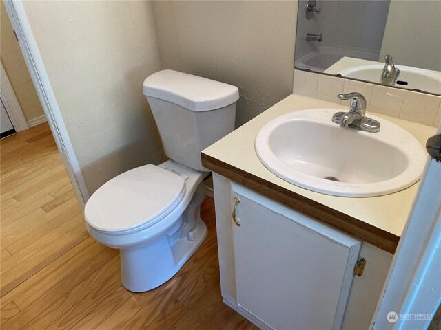 bathroom with vanity, toilet, and hardwood / wood-style floors