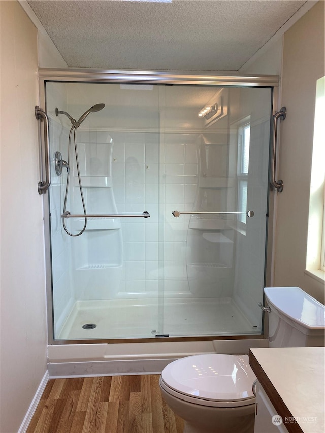 bathroom with toilet, an enclosed shower, a textured ceiling, vanity, and hardwood / wood-style floors