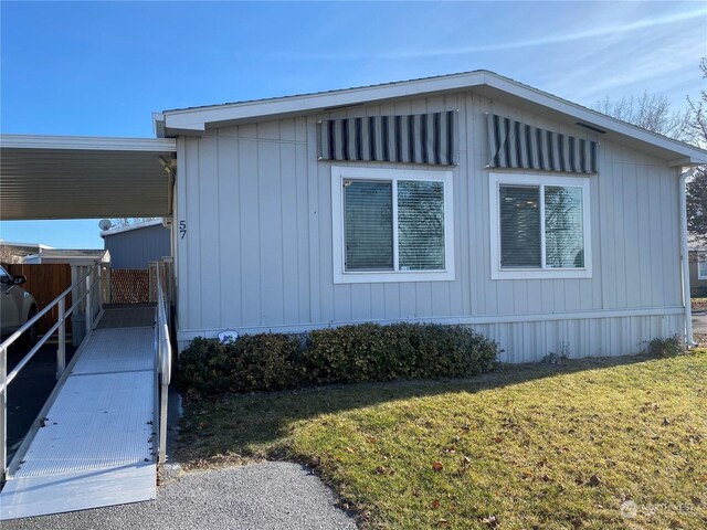 view of side of home featuring a lawn and a carport