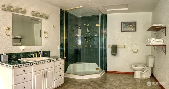 bathroom featuring vanity, toilet, a textured ceiling, and walk in shower