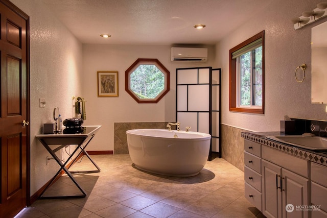 bathroom featuring plenty of natural light, a bath, a wall unit AC, and vanity