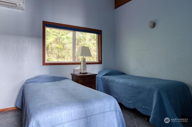 bedroom featuring dark tile patterned floors and a wall mounted AC