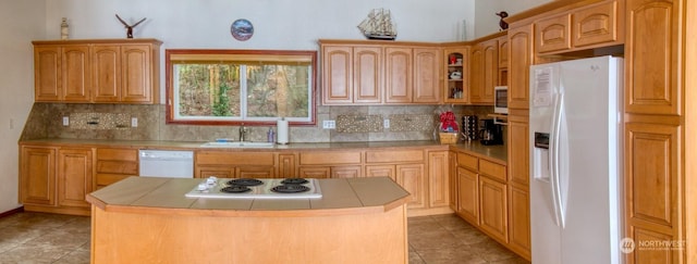 kitchen featuring sink, white appliances, tile countertops, and a center island