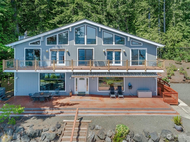 back of house with a wooden deck and a balcony