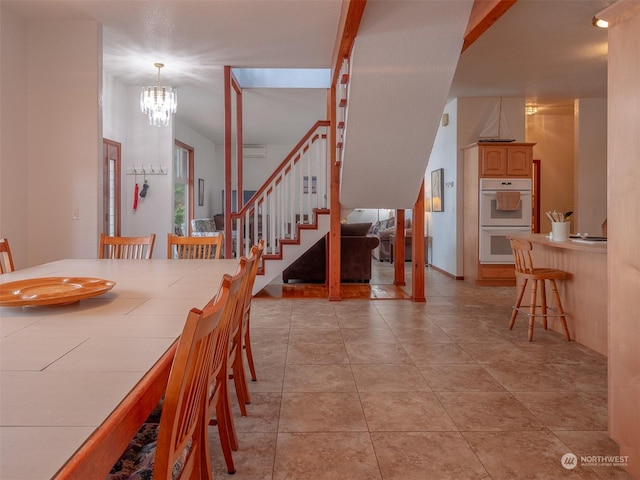 dining area featuring an inviting chandelier and light tile patterned flooring