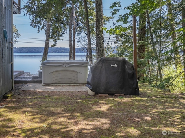 view of outdoor structure with a hot tub and a water view