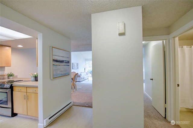 corridor with a textured ceiling and a baseboard heating unit