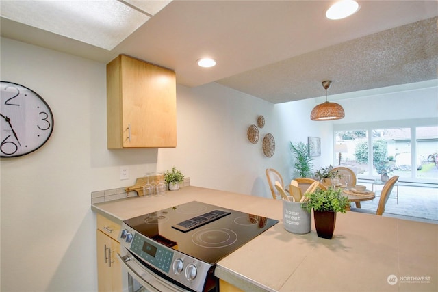 kitchen featuring stainless steel electric range oven, pendant lighting, and light brown cabinetry