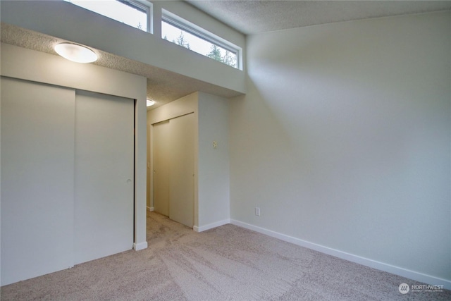 interior space featuring light colored carpet and a textured ceiling