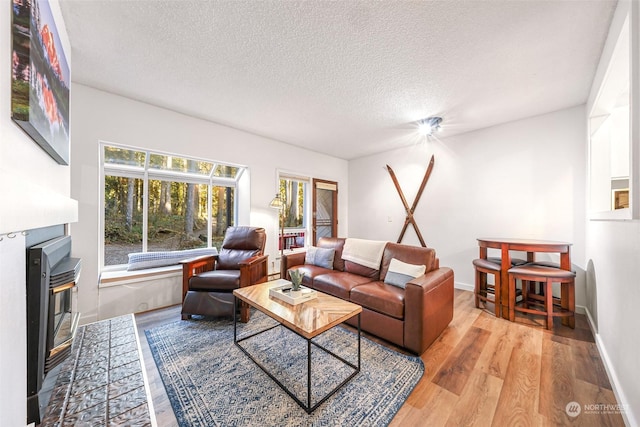 living room with light hardwood / wood-style floors and a textured ceiling