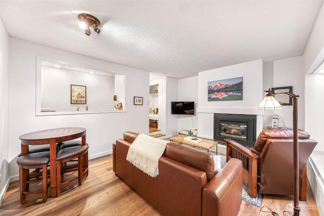 living room featuring light hardwood / wood-style flooring and a textured ceiling