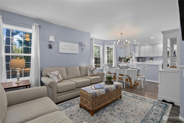 living room featuring sink, dark hardwood / wood-style floors, and a notable chandelier