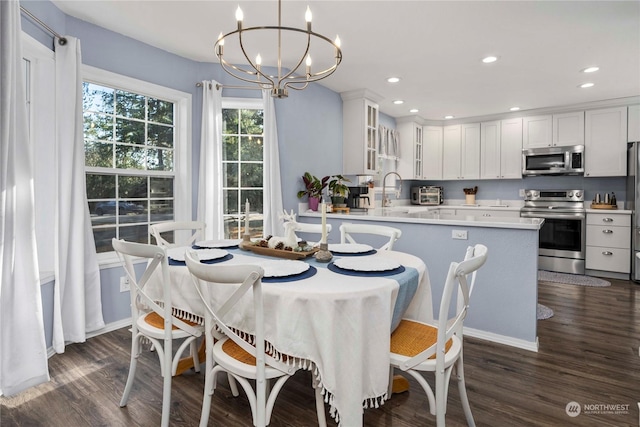 kitchen featuring decorative light fixtures, white cabinetry, kitchen peninsula, and stainless steel appliances