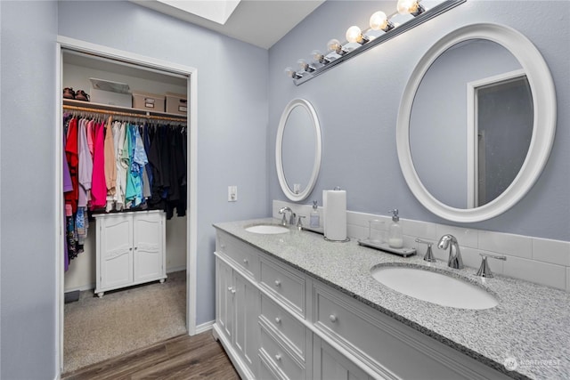 bathroom featuring hardwood / wood-style floors, a skylight, and vanity