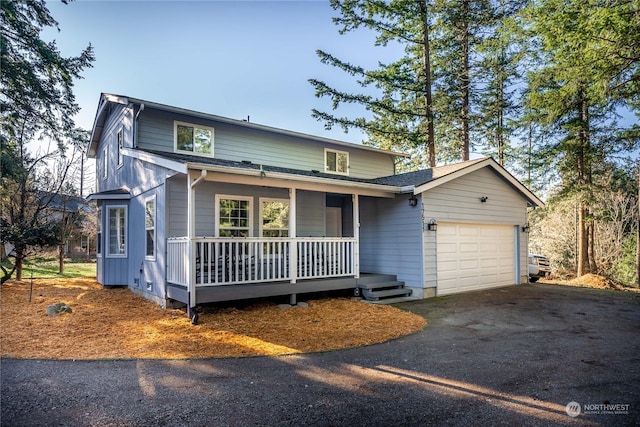 view of property featuring a garage and covered porch