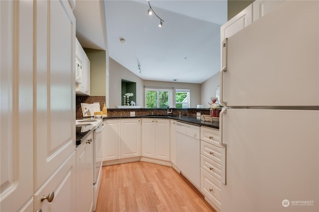 kitchen with white appliances, lofted ceiling, white cabinetry, light hardwood / wood-style floors, and backsplash