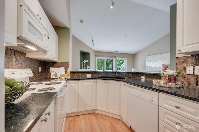 kitchen with sink, white appliances, white cabinets, and vaulted ceiling