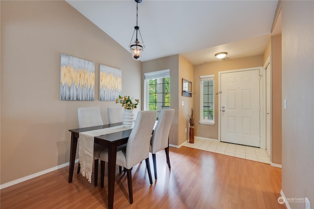 dining space featuring vaulted ceiling and light hardwood / wood-style floors