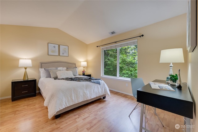 bedroom featuring light wood-type flooring and vaulted ceiling