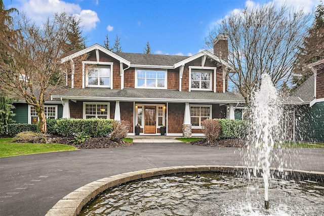 craftsman house with a shingled roof and a chimney