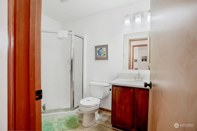 bathroom with vanity, toilet, and an enclosed shower