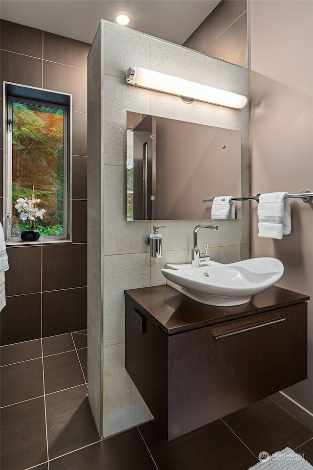 bathroom featuring tile patterned floors, tasteful backsplash, tile walls, and vanity