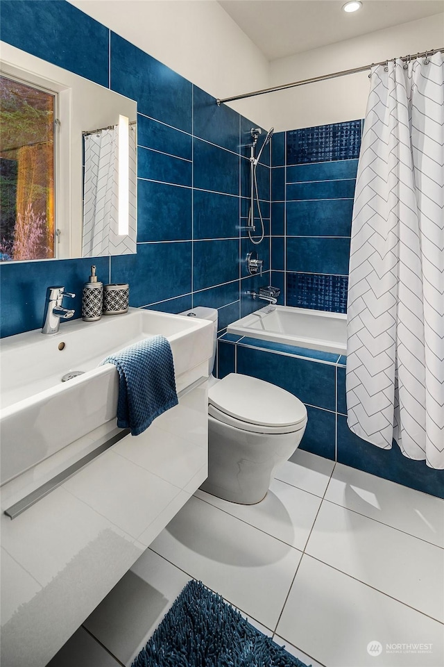 full bathroom featuring toilet, tile patterned floors, tiled shower / bath, vanity, and tile walls