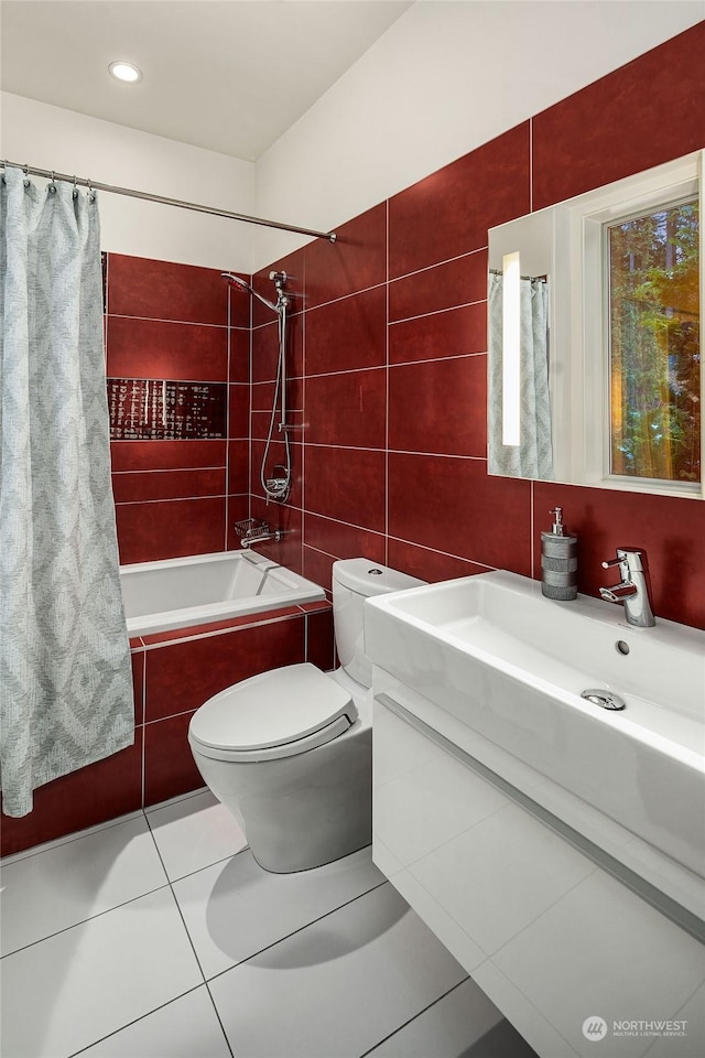 bathroom featuring toilet, tiled shower / bath combo, vanity, tile walls, and tile patterned floors