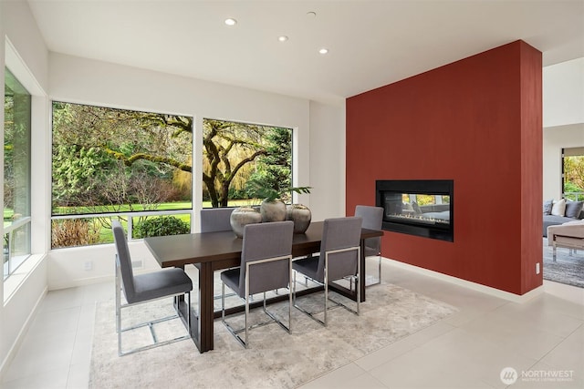 dining space with recessed lighting, baseboards, tile patterned flooring, and a multi sided fireplace