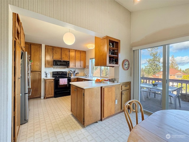 kitchen featuring pendant lighting, sink, black appliances, decorative backsplash, and kitchen peninsula