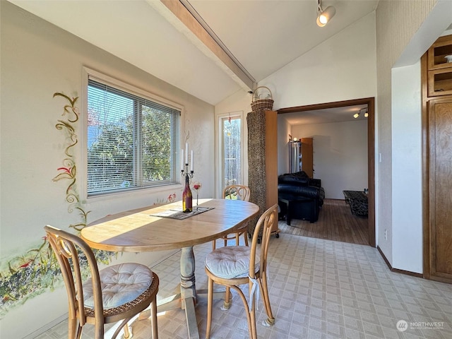 dining area featuring lofted ceiling with beams