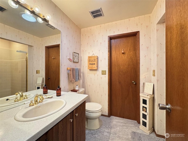 bathroom featuring vanity, a shower, and toilet