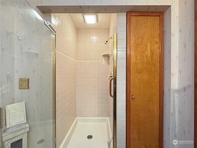 bathroom with a shower with door