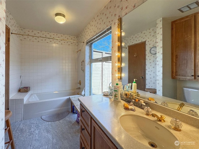 full bathroom with vanity, toilet, and tiled shower / bath combo