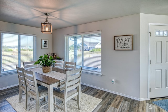 dining area featuring dark wood-type flooring and a textured ceiling