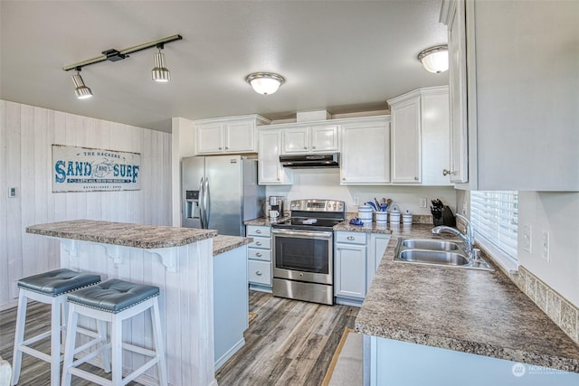 kitchen with sink, a breakfast bar, appliances with stainless steel finishes, a center island, and white cabinets